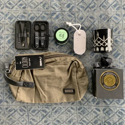 a toilet bag, manicure kit, balms and candles layed out on display